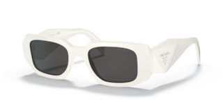 Occhiali da sole Prada PR 17WS Frosted Vanilla donna, montatura color vaniglia chiaro con lenti scure, posti su una superfici