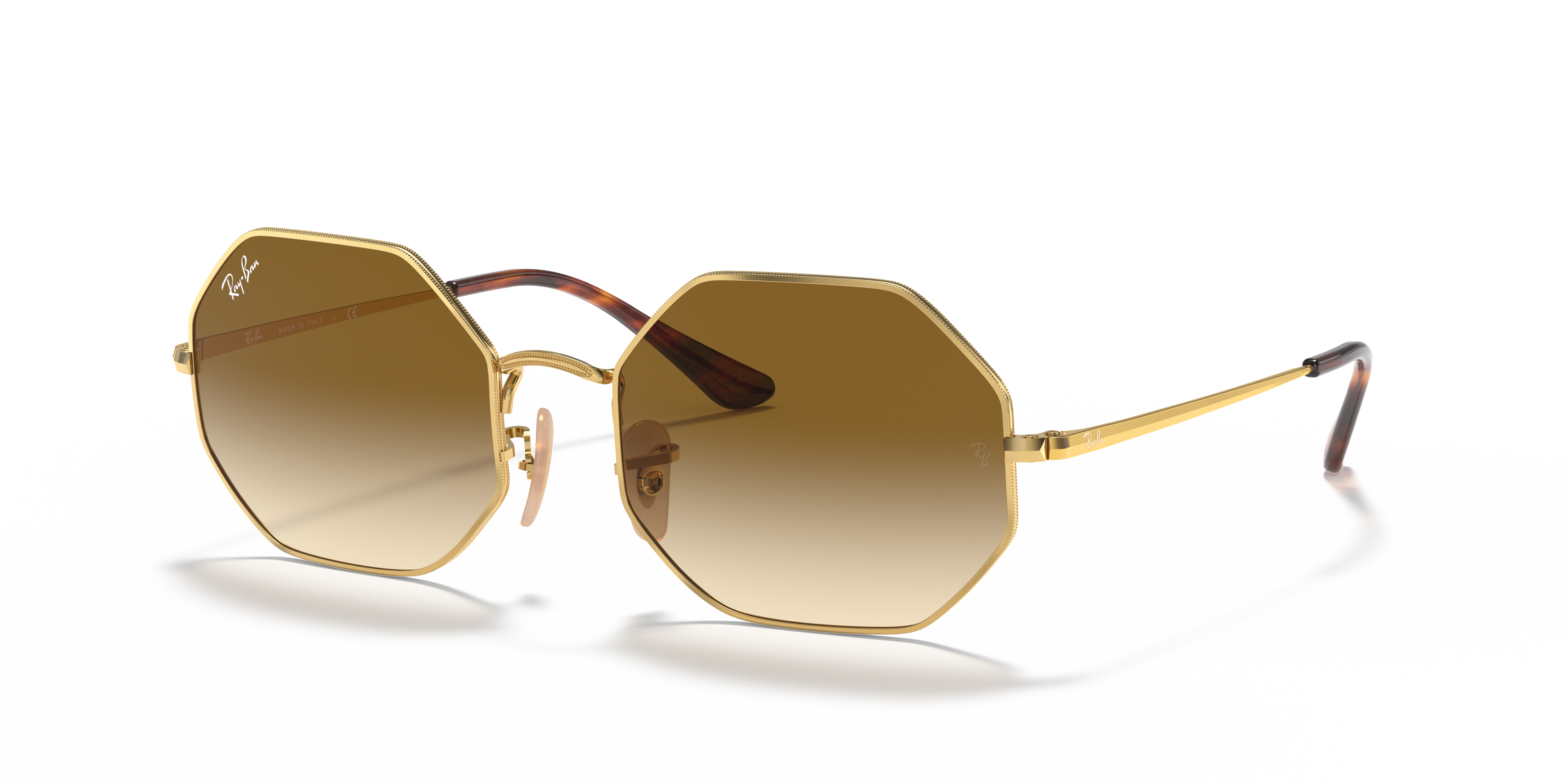 Occhiali da sole Ray-Ban Octagon 0RB1972 in metallo Arista Gold con lenti marroni, indossati da una persona in un ambiente so