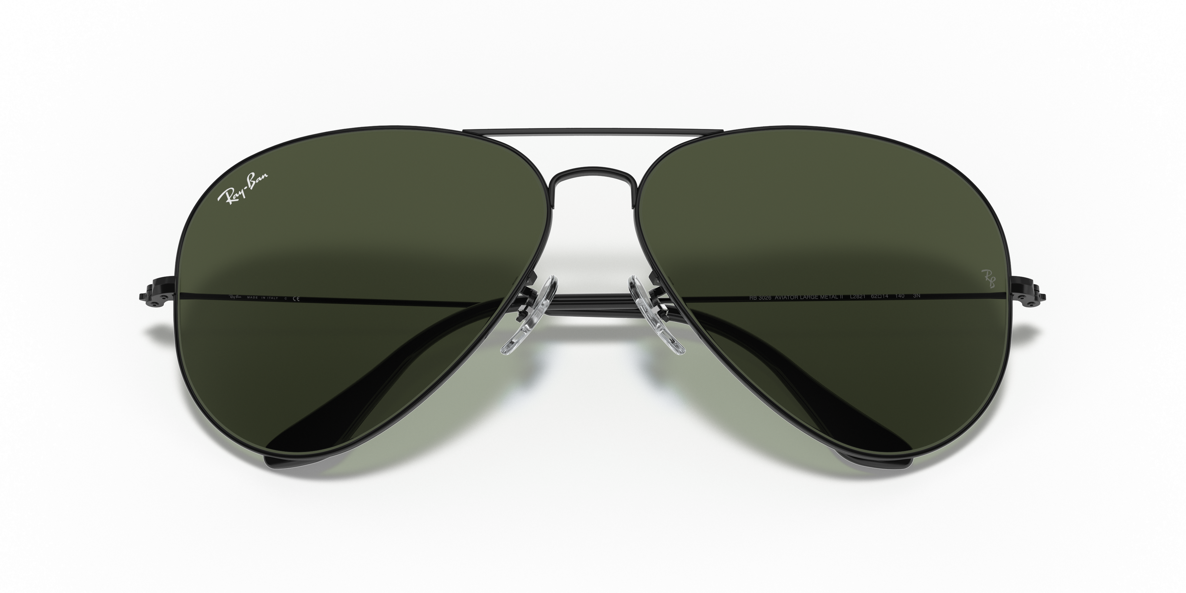Occhiali da sole Ray-Ban Aviator Large Metal II 0RB3026 con montatura oro Arista e lenti scure, posti su una superficie bianc