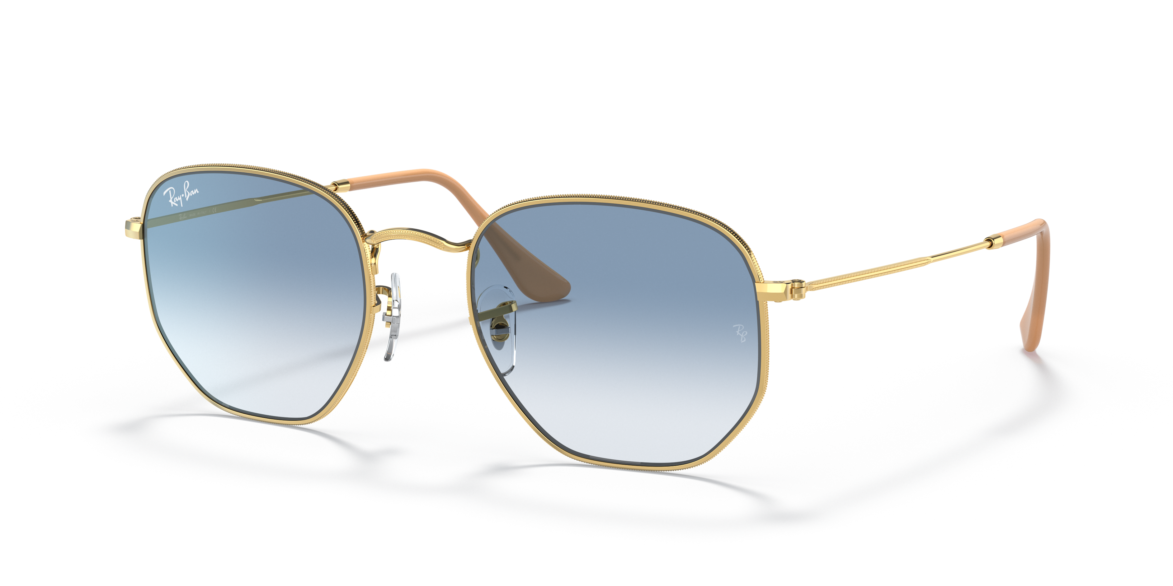Occhiali da sole Ray-Ban Hexagonal 0RB3548 con montatura in metallo dorato Arista Gold e lenti scure, appoggiati su una super