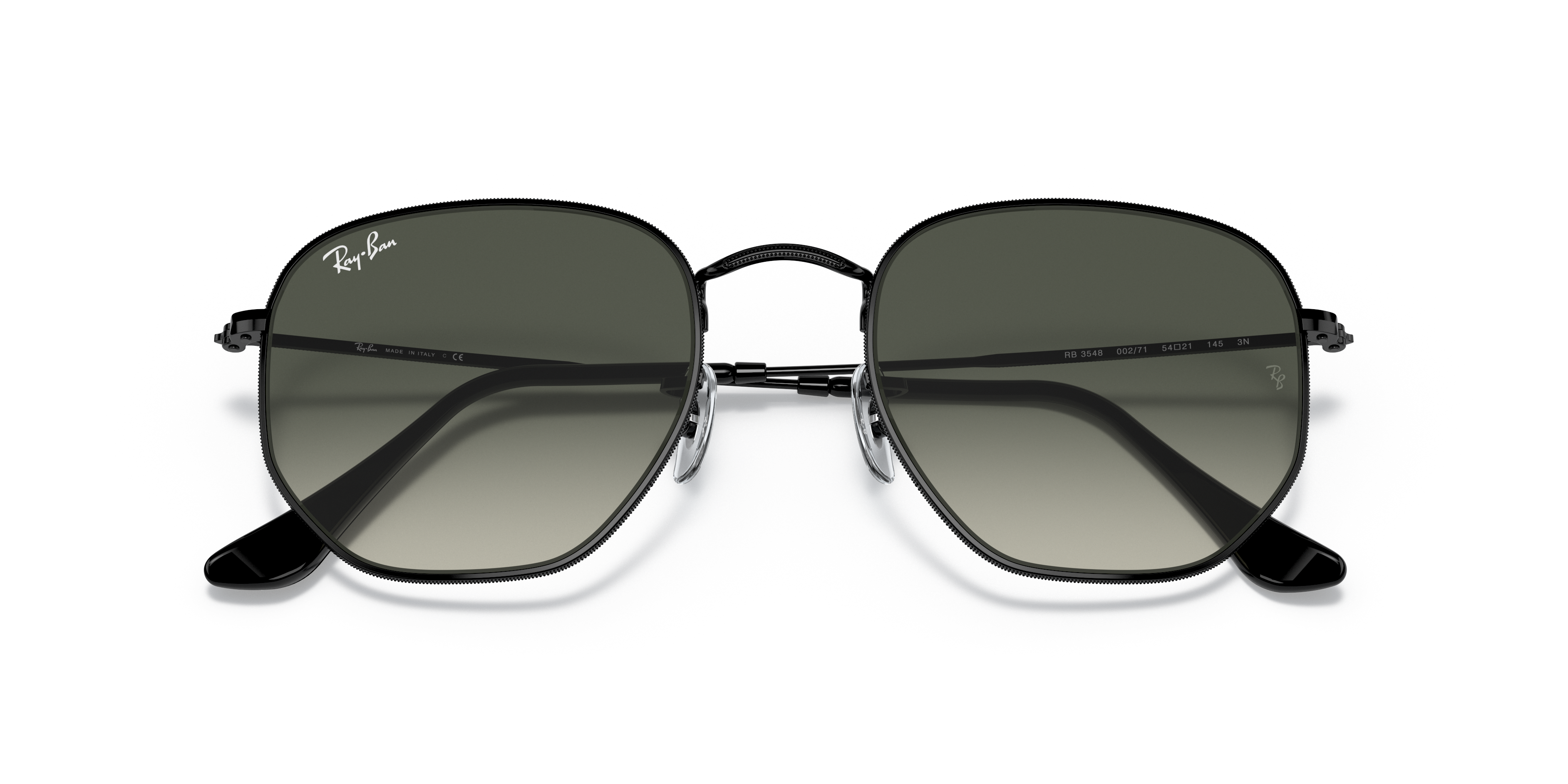 Occhiali da sole Ray-Ban Hexagonal 0RB3548 con montatura in metallo dorato Arista Gold e lenti scure, appoggiati su una super