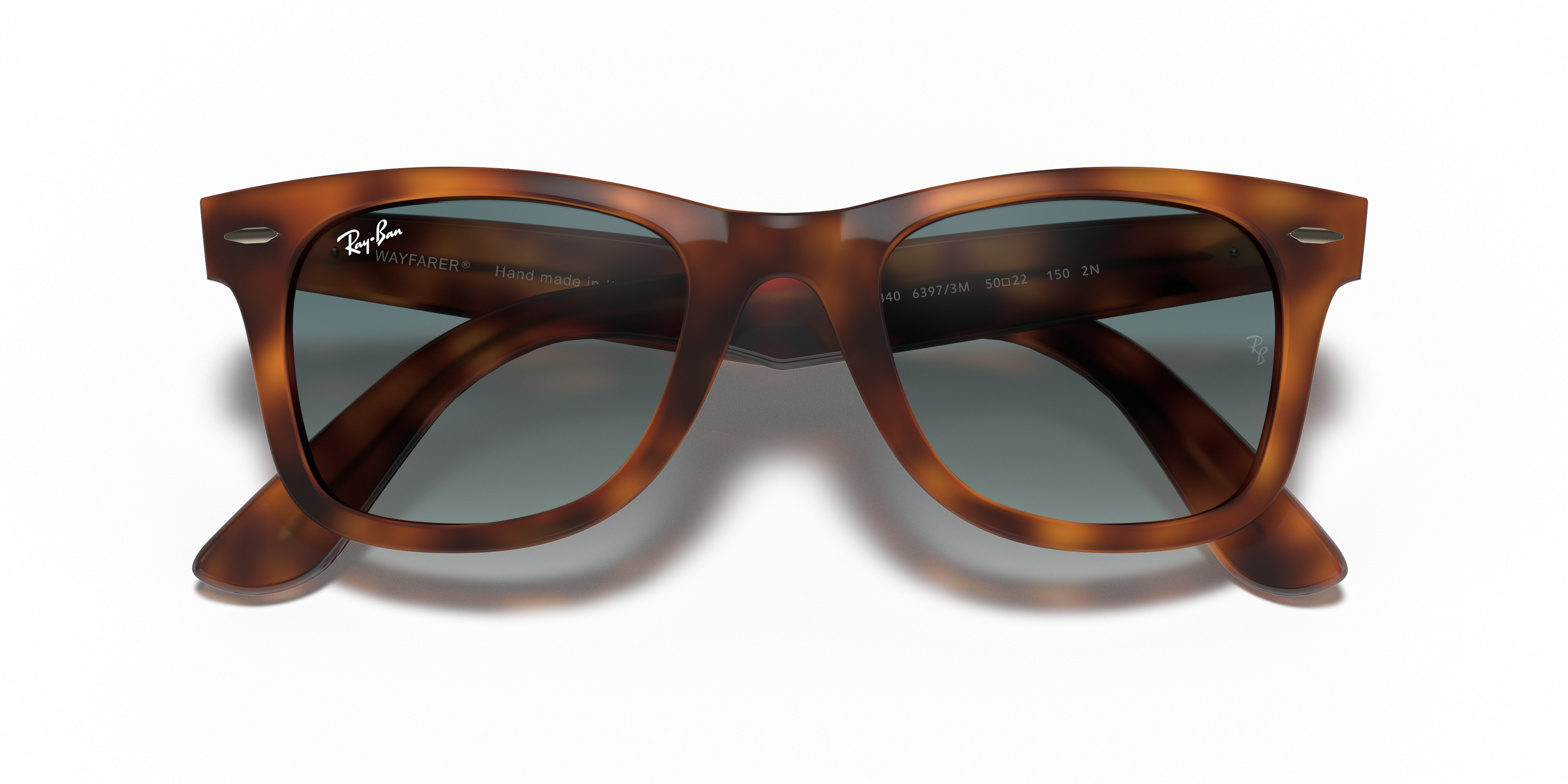 Occhiali da sole Ray-Ban Wayfarer 0RB4340 Light Havana unisex posati su una superficie chiara, che mostra la montatura tartar