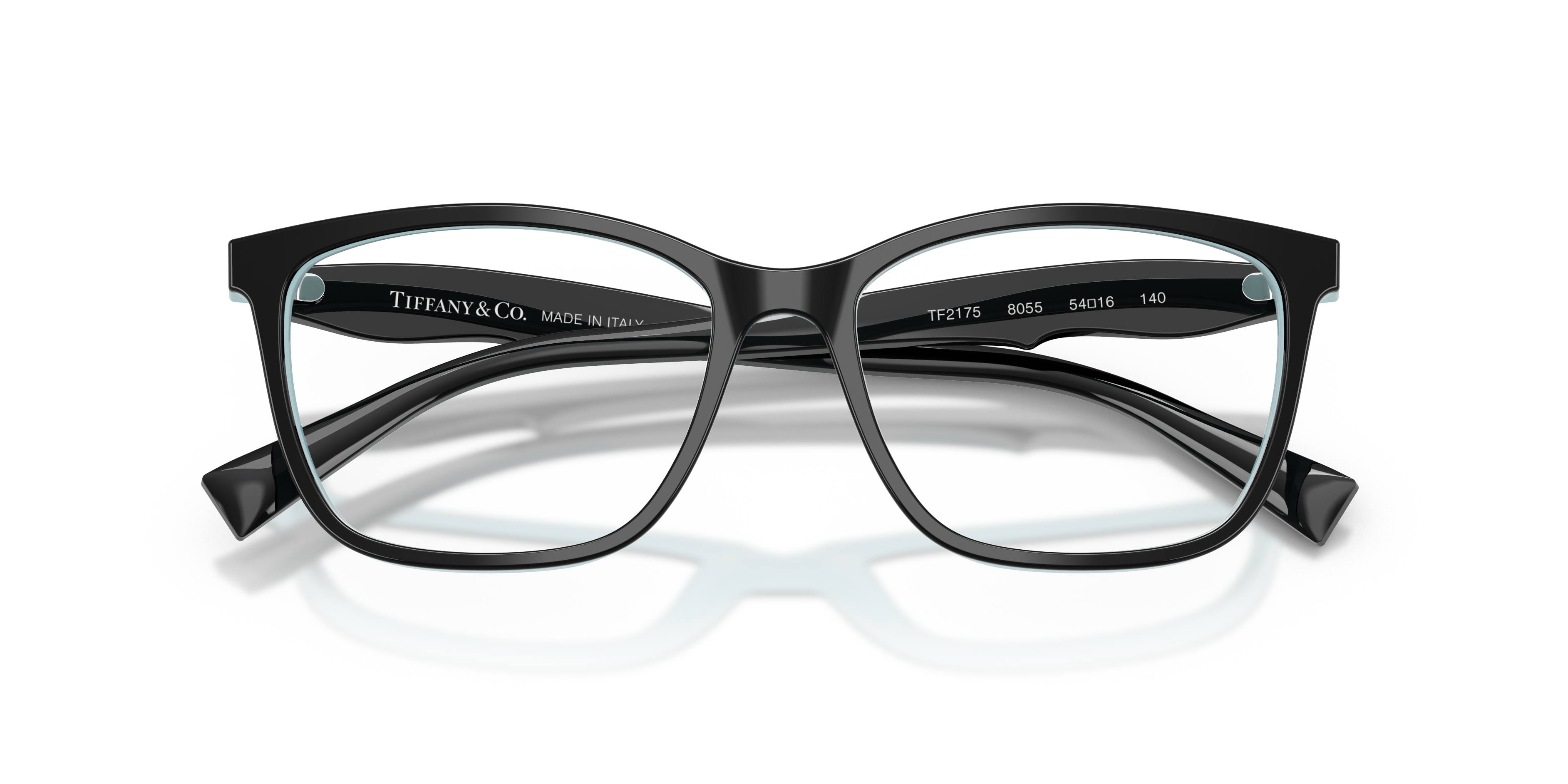 Donna che indossa occhiali da sole Tiffany & Co. TF2175 con montatura Havana e interno Tiffany Blue, in primo piano su sfondo