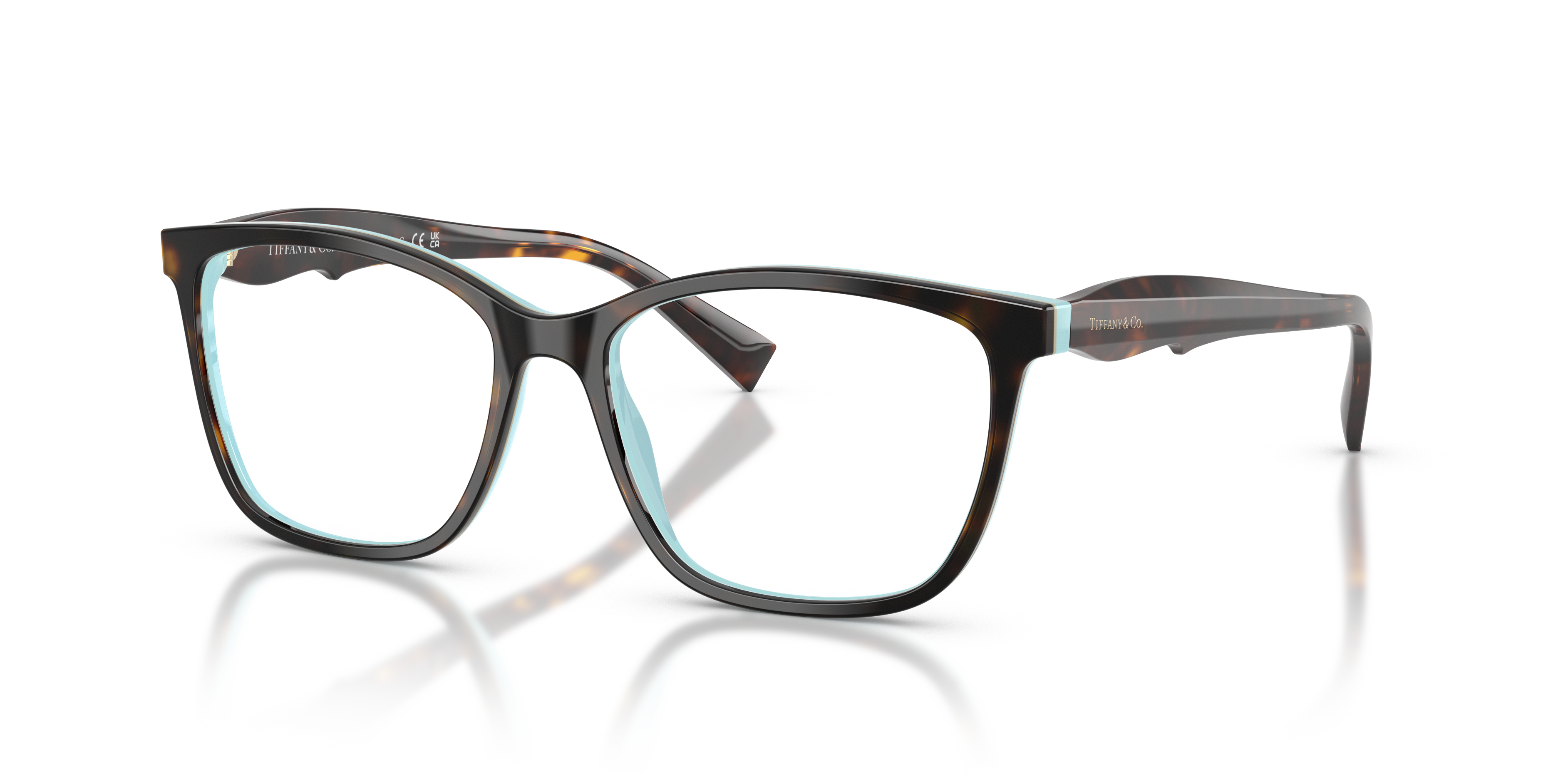 Donna che indossa occhiali da sole Tiffany & Co. TF2175 con montatura Havana e interno Tiffany Blue, in primo piano su sfondo