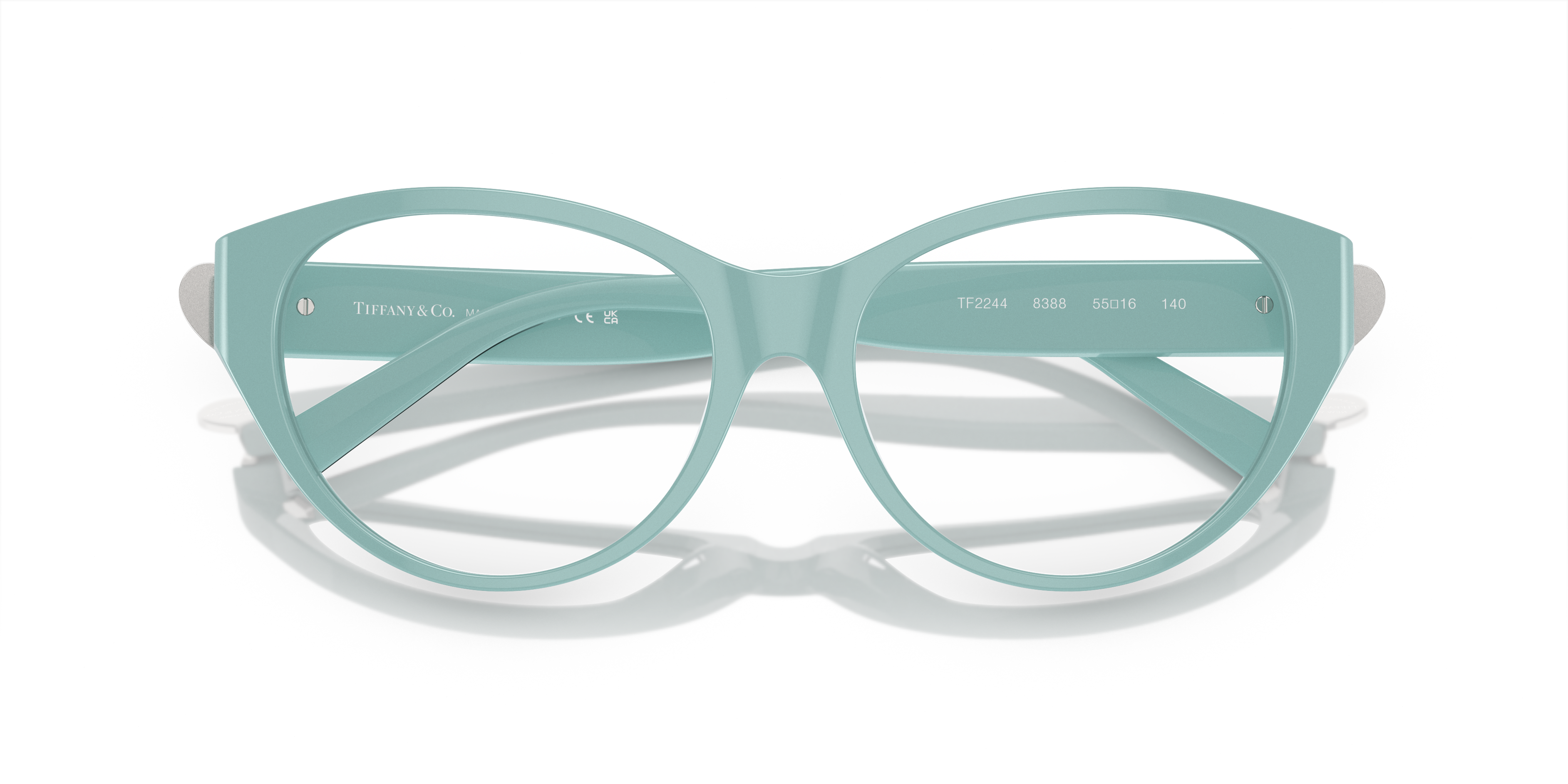 Occhiali da sole Tiffany TF2244 da donna con montatura Havana e lenti scure, appoggiati su una superficie chiara.