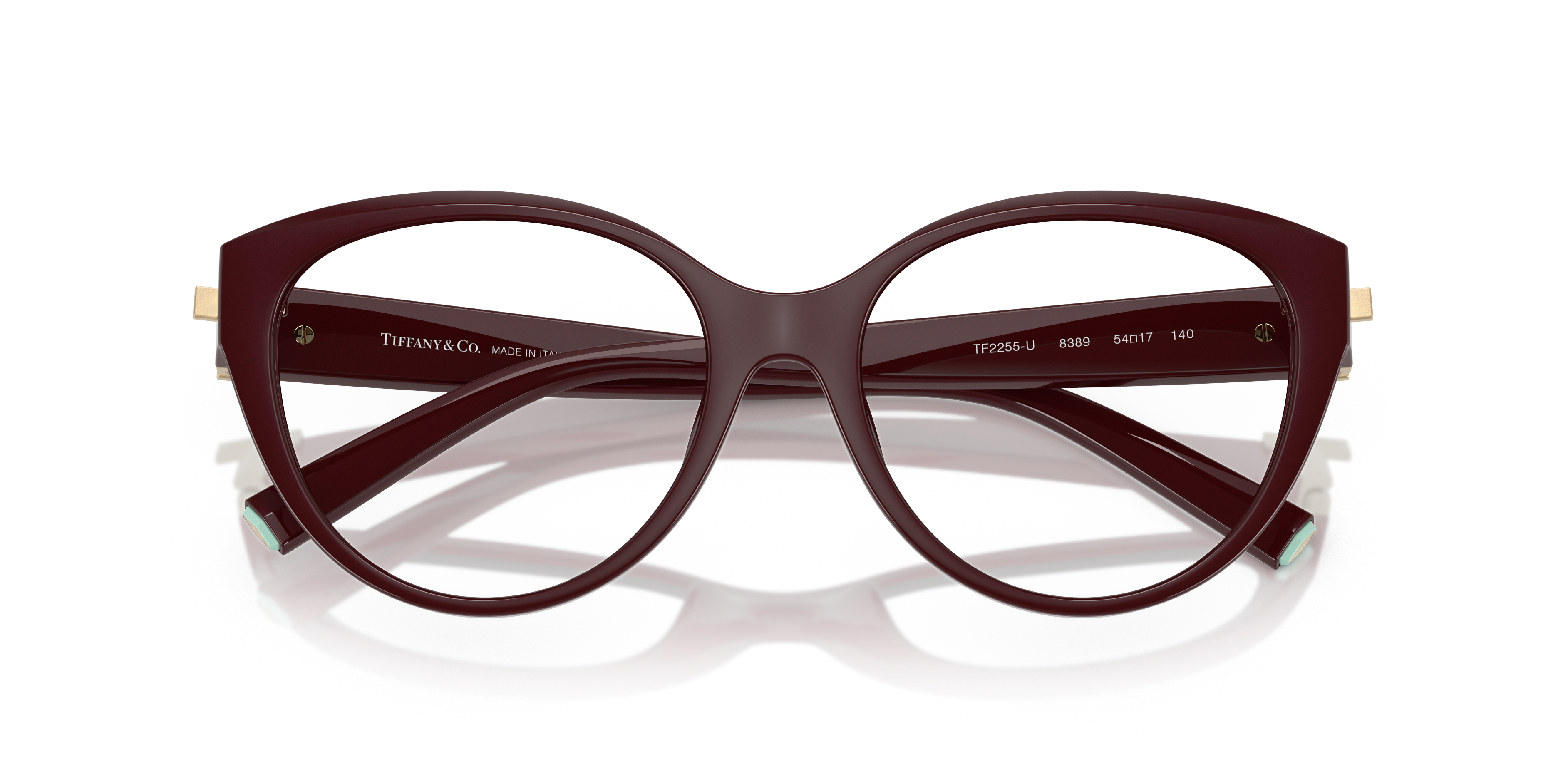 Occhiali da sole Tiffany TF2255U neri da donna con montatura cat-eye e logo argento sulle aste, poggiano su una superficie ch