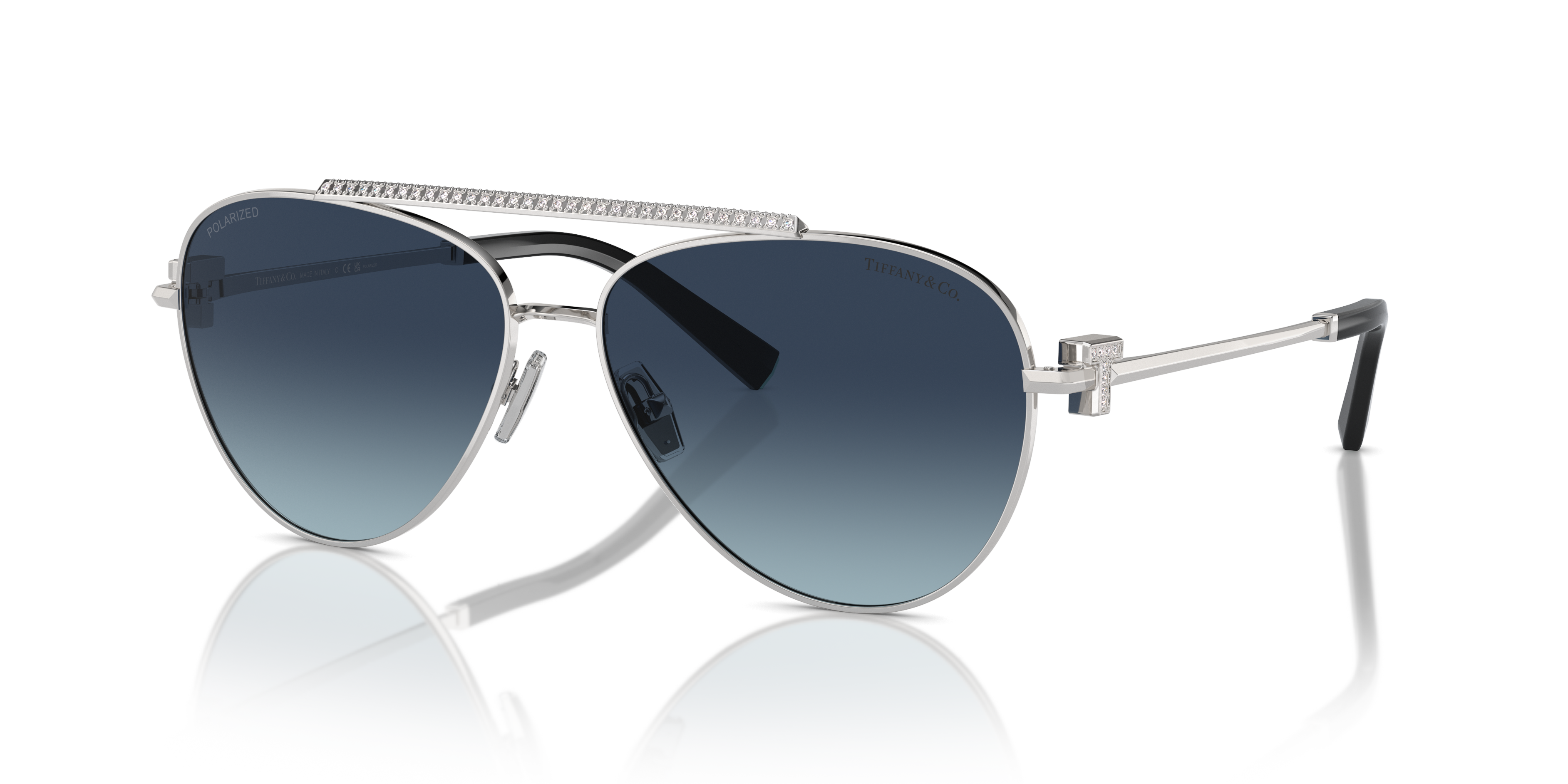 Occhiali da sole Tiffany TF3101B donna di colore argento, con montatura in metallo, poggiati su superficie chiara.