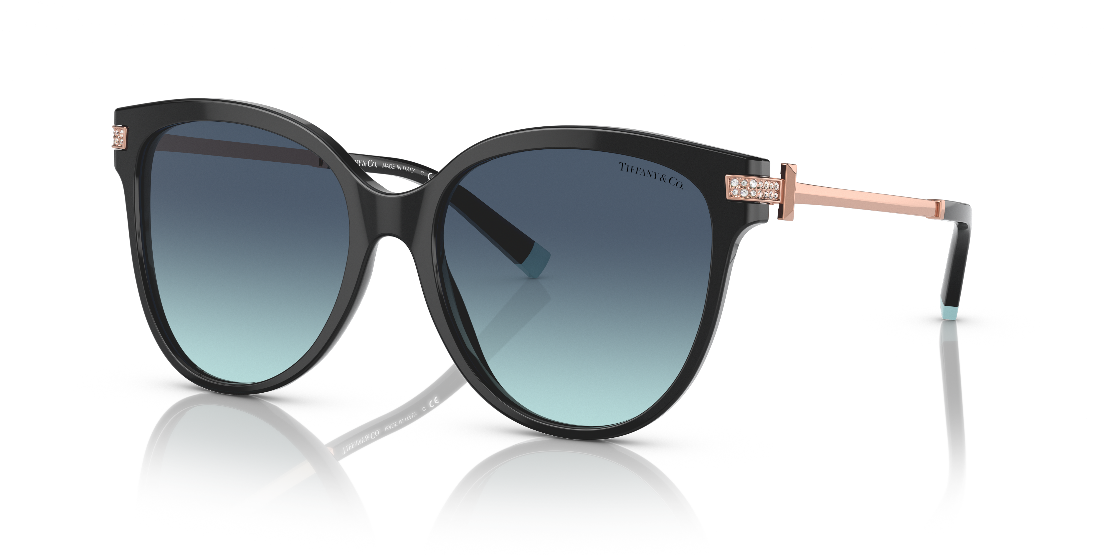 Occhiali da sole Tiffany TF4193B neri da donna con montatura cat-eye e dettagli in cristallo sulle aste, appoggiati su una su