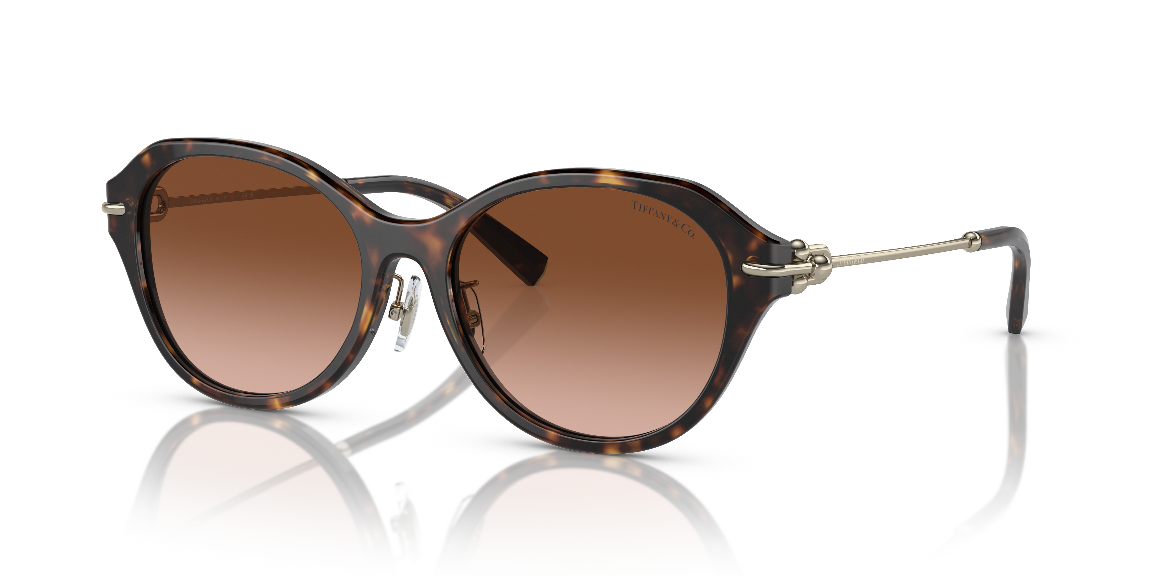 Occhiali da sole Tiffany & Co. modello TF4210D da donna colore Havana appoggiati su una superficie chiara, che mostra la mont