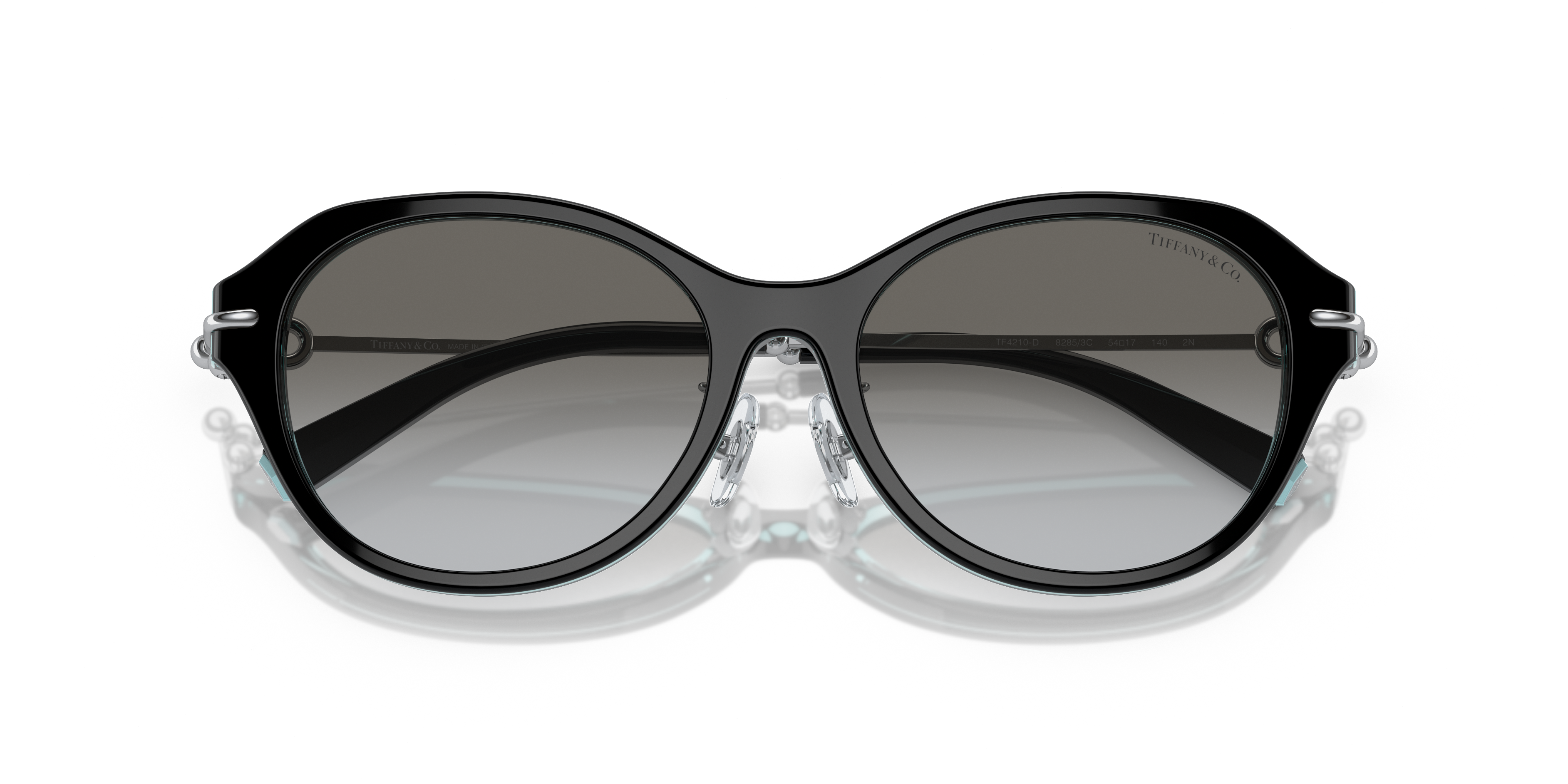 Occhiali da sole Tiffany & Co. modello TF4210D da donna colore Havana appoggiati su una superficie chiara, che mostra la mont