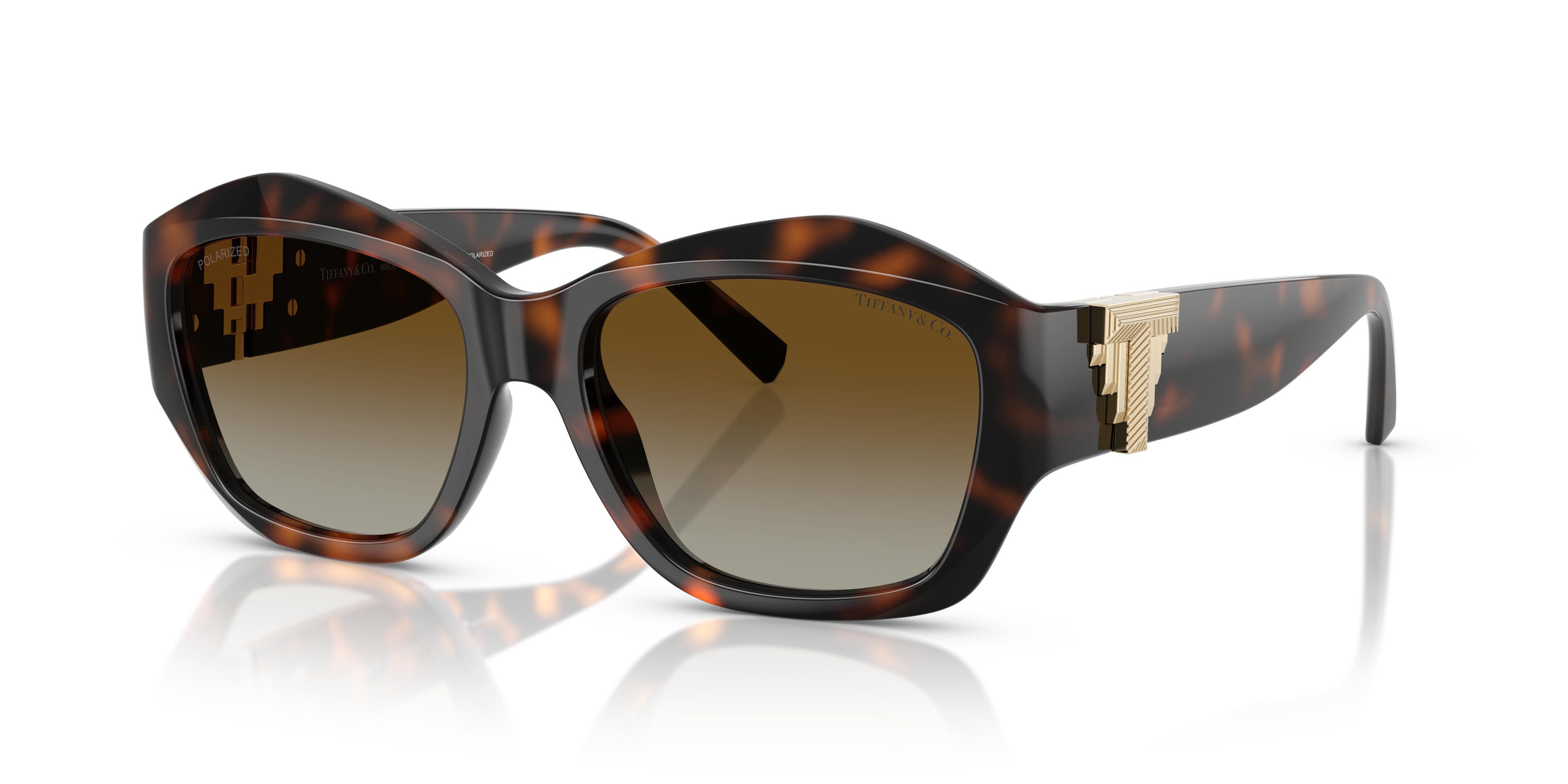 Occhiali da sole Tiffany TF4233U da donna in colore Havana con montatura squadrata e aste decorate, appoggiati su una superfi