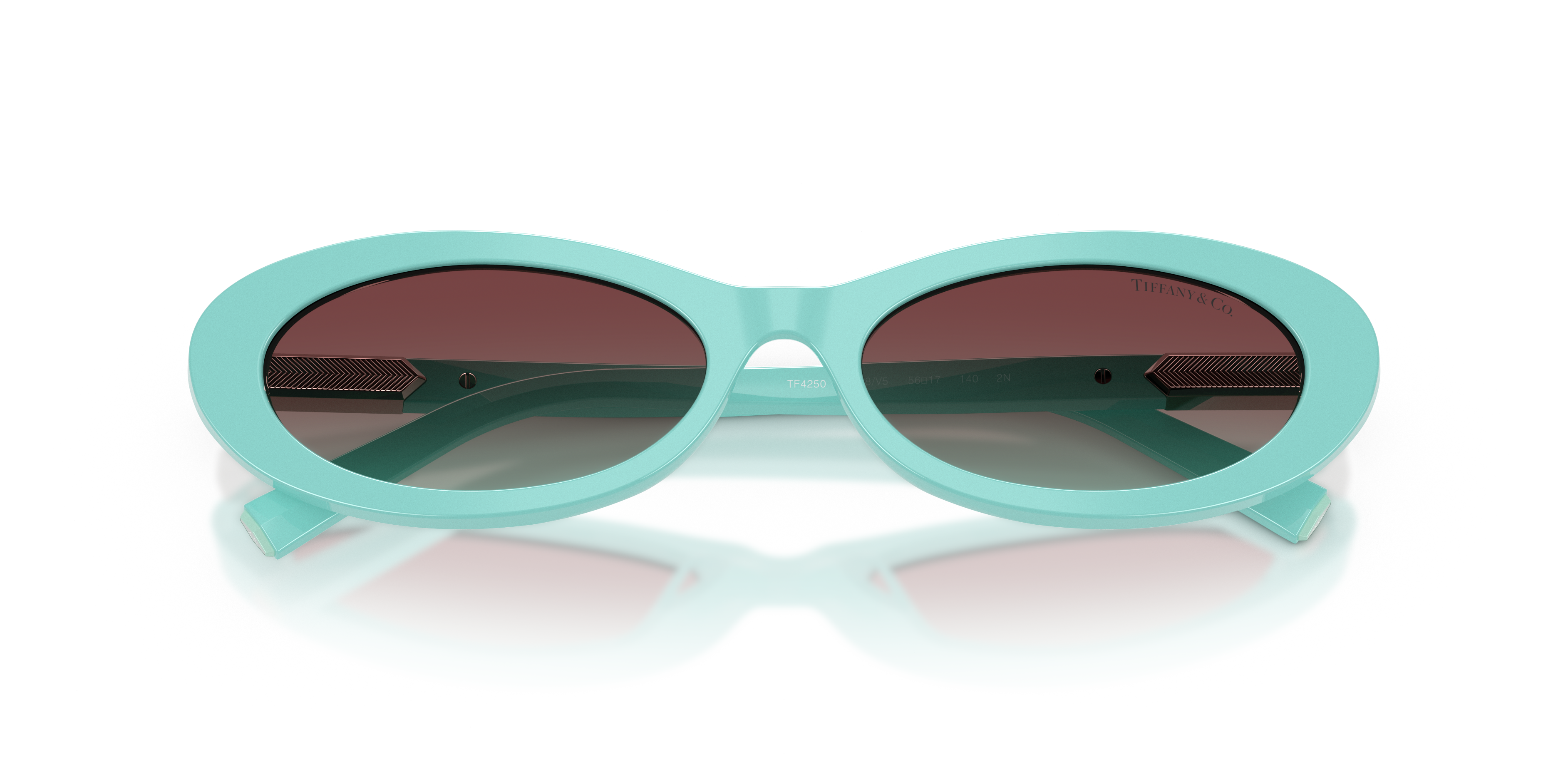 Occhiali da sole Tiffany & Co. modello TF4250 di colore Havana per donna, appoggiati su una superficie chiara