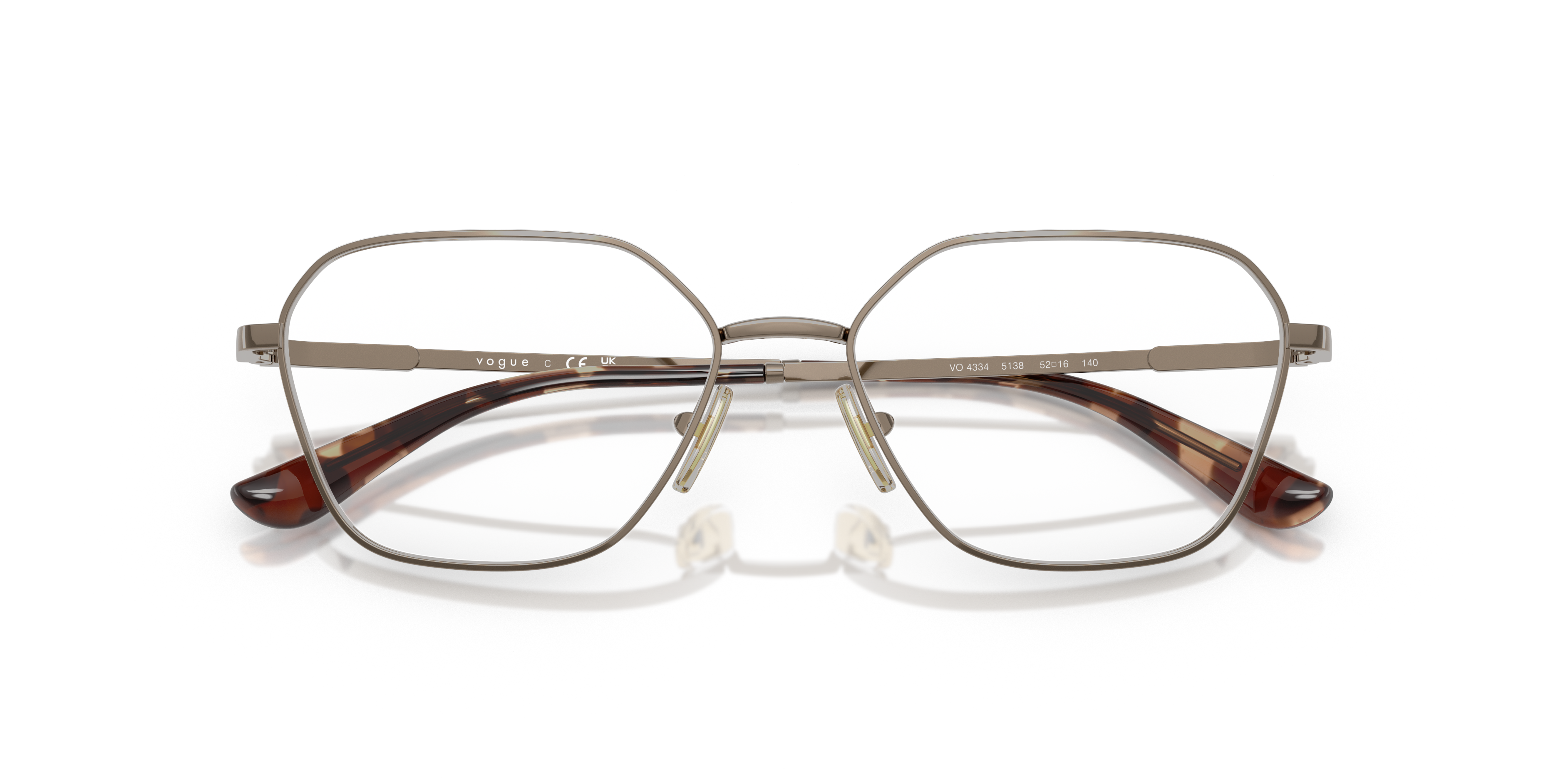 Donna con occhiali da sole Vogue Eyewear VO4334 oro rosa, montatura sottile in metallo lucido e lenti scure, seduta all'apert