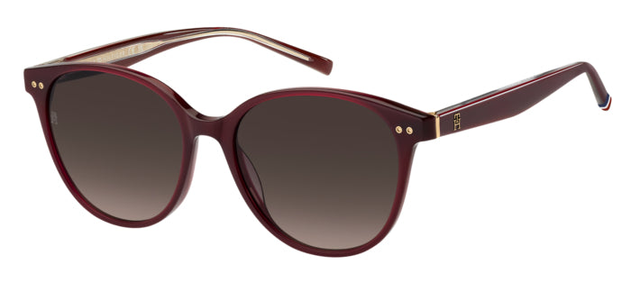 Occhiali da sole donna Tommy Hilfiger TH 2289/S color avana, montatura squadrata con lenti scure, posti su una superficie chi