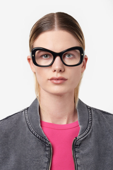 Donna con occhiali da vista DSQUARED2 neri modello D2 0138, in posa frontale che mette in risalto il design della montatura.