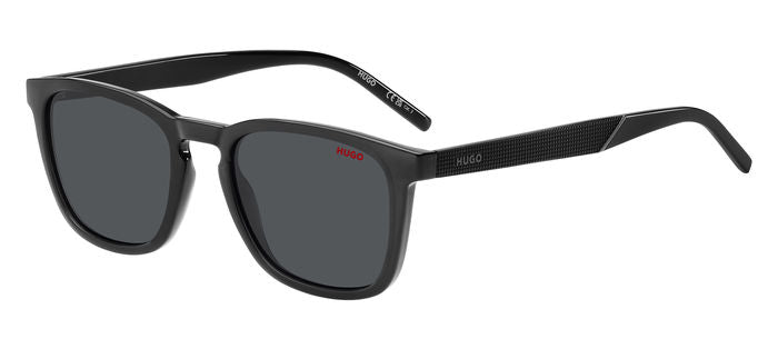 Primo piano di occhiali da sole HUGO da uomo modello HG 1306/S grigi, con lenti scure e montatura elegante.