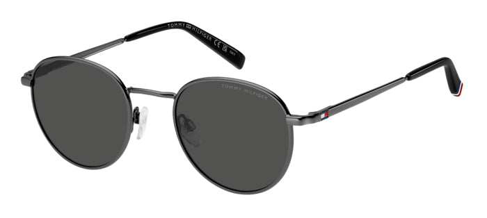 Occhiali da sole Tommy Hilfiger TH 2217/S con montatura metallica dorata, lenti scure e aste sottili, posizionati su una supe