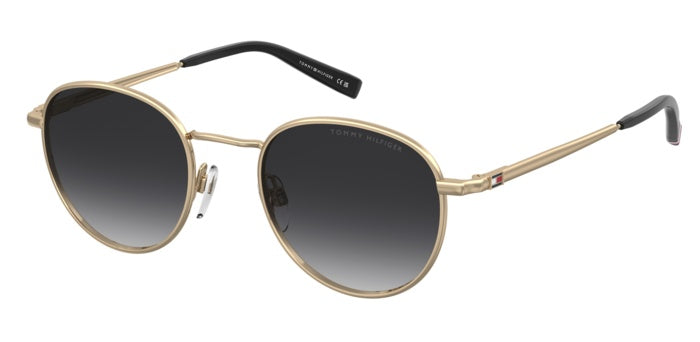 Occhiali da sole Tommy Hilfiger TH 2217/S con montatura metallica dorata, lenti scure e aste sottili, posizionati su una supe