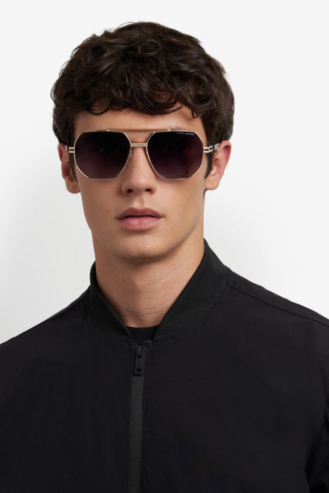 Occhiali da sole uomo Marc Jacobs MARC 784/S con montatura in metallo color oro e lenti scure, posti su uno sfondo neutro.