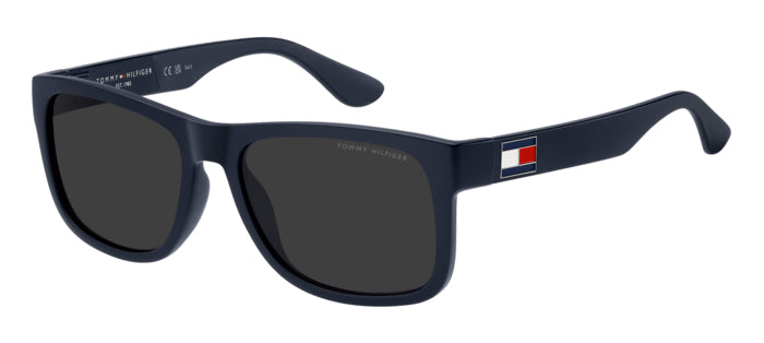 Occhiali da sole Tommy Hilfiger rossi modello TH 1556/N/S indossati da un uomo, con lenti scure e montatura in acetato lucido